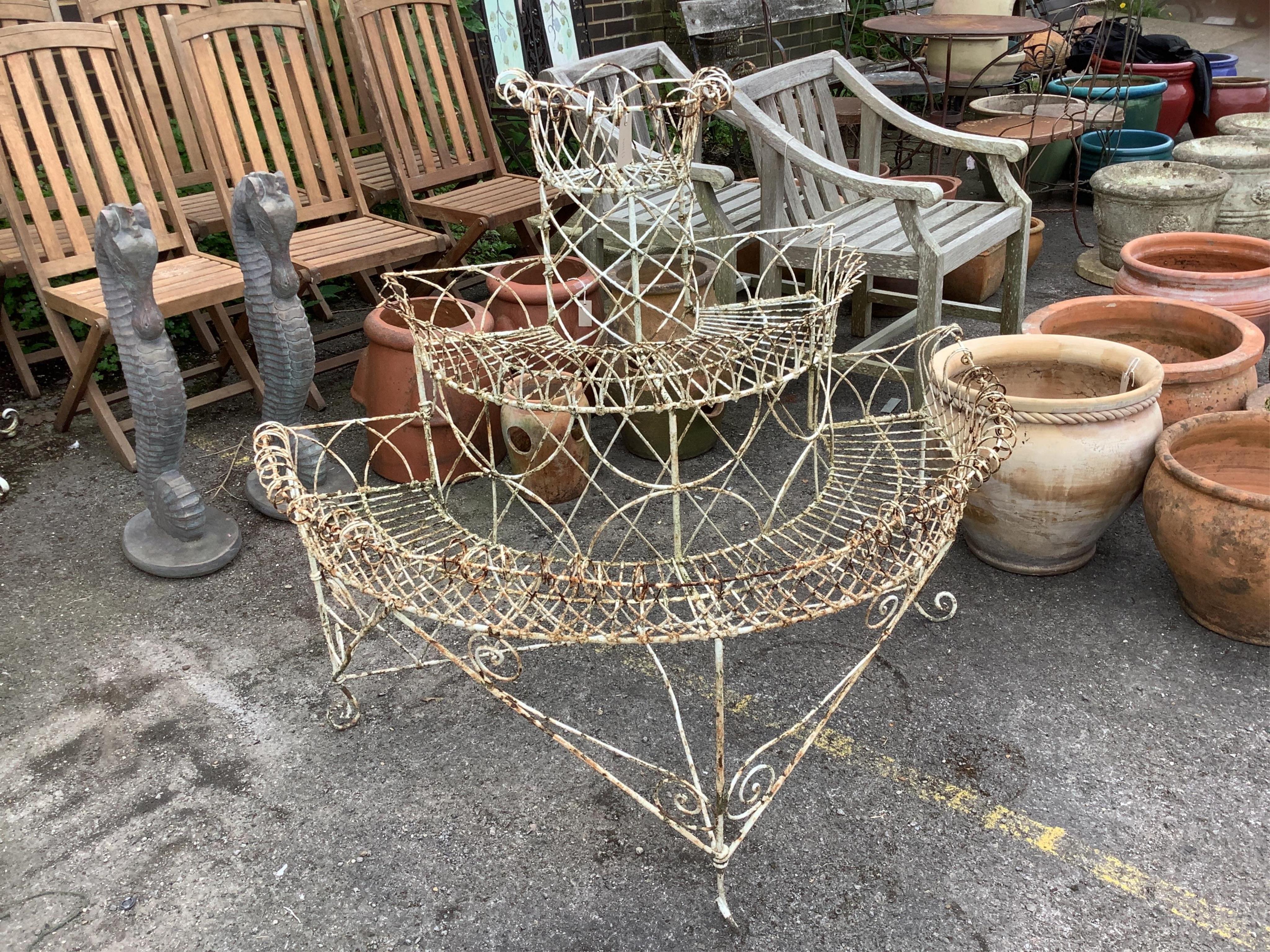 A painted wirework three tier bow front pot stand, width 116cm, depth 64cm, height 107cm